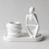 Conjunto Decorativo Pensadora com Vaso e Bandeja em Cimento Branco Conjunto Decorativo Pensadora com Vaso e Bandeja em Cimento Branco, vista em perspectiva