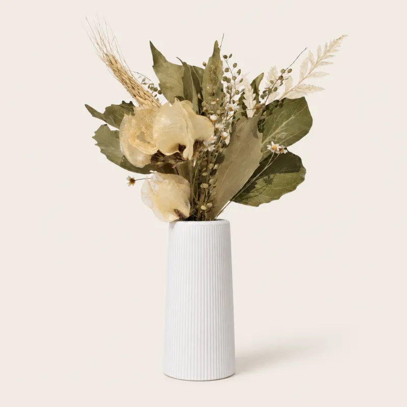 Arranjo de flores secas em vaso de cimento branco listrado
